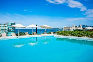 Stylish ocean-view condo with pool, gym, private balcony, AC, & WiFi - 0