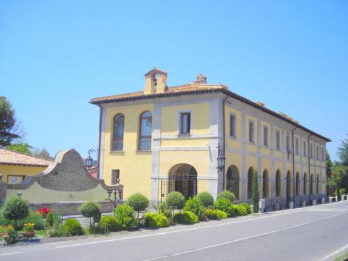 a large white building with a clock on the side of it, Relais Il Postiglione - Antica Posta dei Chigi in Campagnano Di Roma