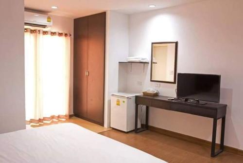 a hotel room with a television and a bed, Field Town Apartment in Nakhon Nayok