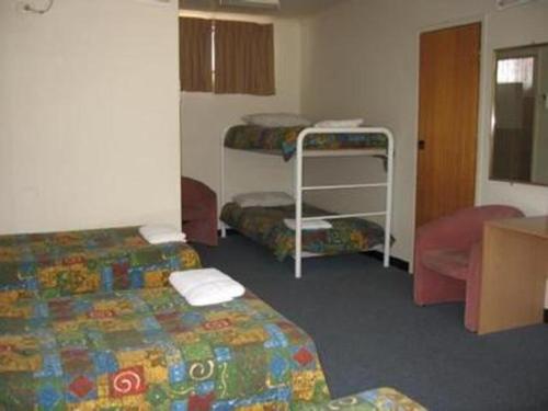 a small room with a bed and a bunk bed, Red Cedars Motel in Canberra