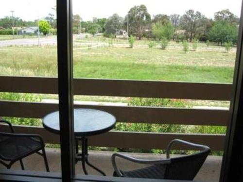 a patio area with a table and chairs, Red Cedars Motel in Canberra
