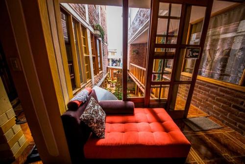 a dog sitting on a red couch in a living room, Hotel Donde Ivan in Banos
