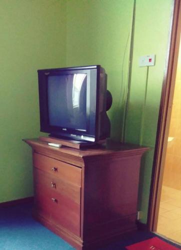 a tv sitting on top of a stand in a room, Hotel Ayu Villa in Kangar