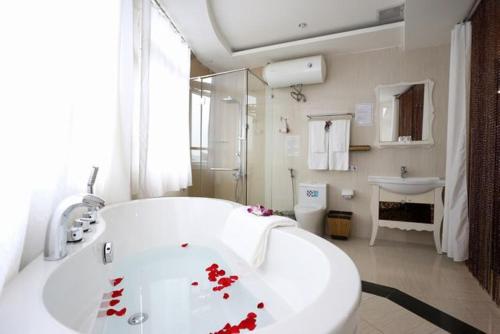 a white bath tub sitting next to a white sink, Pho Nui Hotel in Dalat