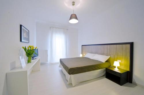 a bedroom with a white bed and a lamp, Vico Amato Residenza in Sulmona