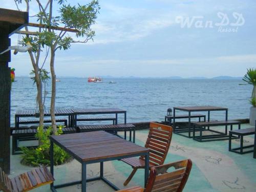 a beach area with chairs, tables, and umbrellas, Wan DD Resort in Pattaya