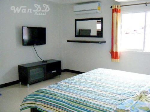 a bedroom with a television and a bed, Wan DD Resort in Pattaya