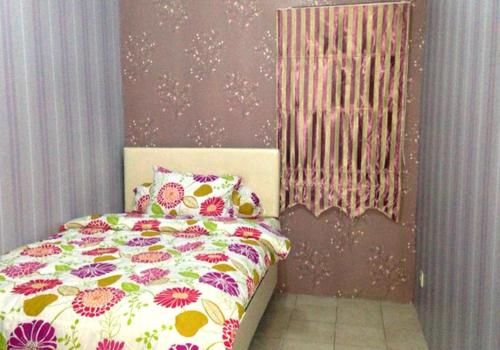 a bedroom with a pink bedspread and a pink wall, Apartemen Mediterania Garden by Netty in Jakarta