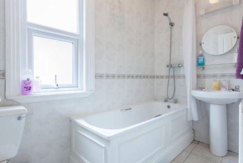 a white bath tub sitting next to a white sink, Home2Home-Rooms in London