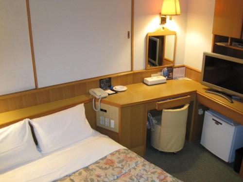 a hotel room with a bed and a television, Hyuga Dai-ichi Hotel in Hyuga