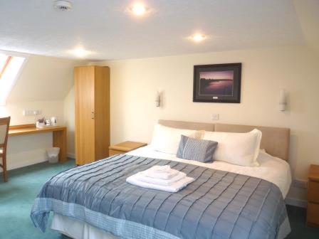 a hotel room with a bed and a television, Pentland Lodge House in Thurso