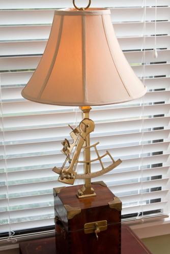 a lamp sitting on top of a wooden table next to a window, Blue Heron Inn in Amelia Island (FL)