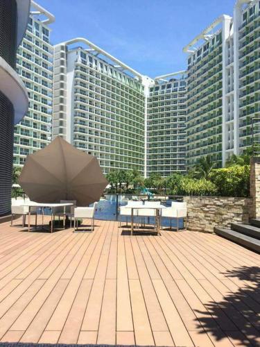 a patio area with chairs, tables and umbrellas, Azure Urban Resort Maui Unit in Manila