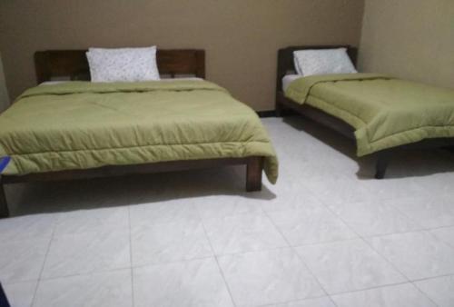 two beds in a room with a white bedspread, Cinnamon Guest House in Ende