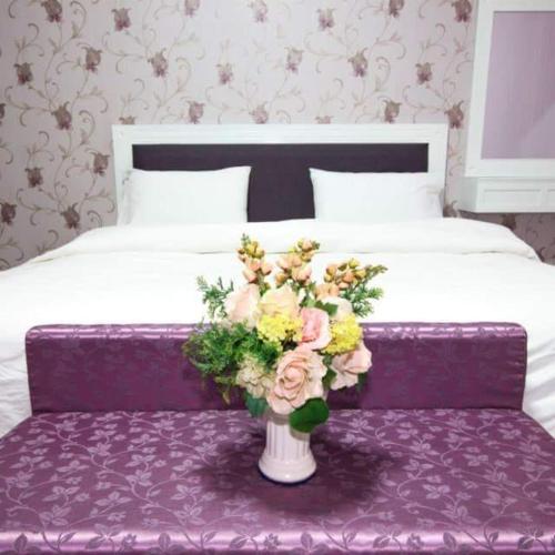 a bouquet of flowers sits on a bed in a hotel room, Baan Dara Resort in Saraburi