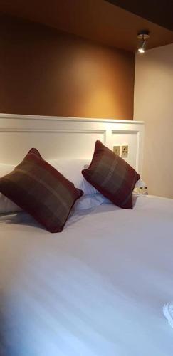a bed with two pillows on top of it, The Silverdale Hotel in Lancaster