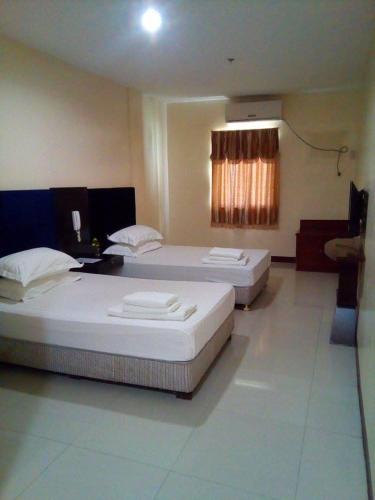 a hotel room with two beds and a television, Asia Novo Boutique Hotel - Ozamis in Ozamiz City