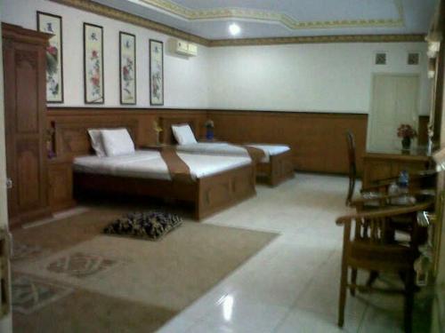 a room with a bed, chair, table and a lamp, Hotel Wiwi Perkasa 2 in Indramayu