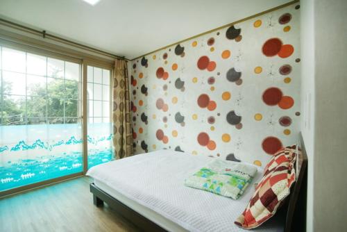 a bed sitting in a bedroom next to a window, Olle House in Jeju