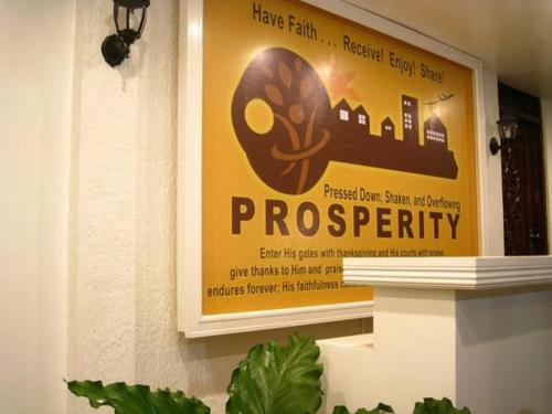 a sign on a wall in front of a building, Prosperity Inn in Ilocos Sur