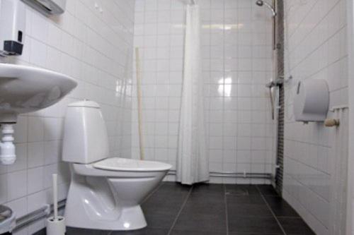 a white toilet sitting in a bathroom next to a shower, Orebro City Hostel in Orebro