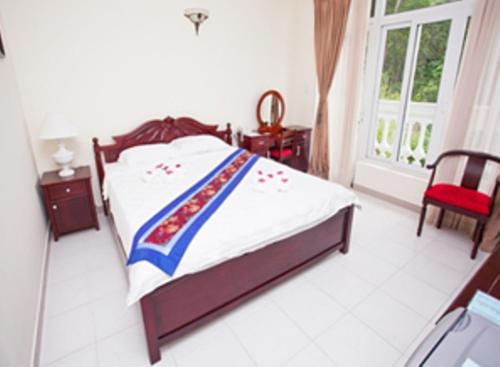 a bedroom with a bed and a dresser, Nathalie's Vung Tau Hotel and Restaurant in Vung Tau