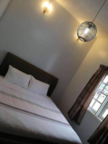 a bedroom with a bed and a lamp, Cameron Greenhill Apartment in Cameron Highlands