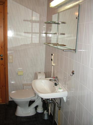 a bathroom with a toilet, sink and mirror, Yllasriemu Apartments in Akaslompolo