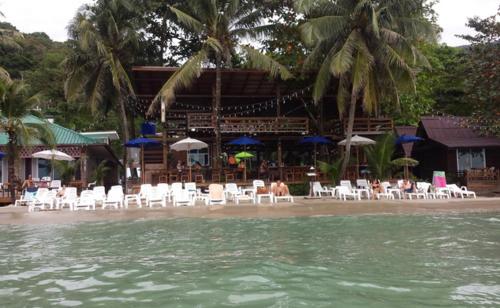 people are lounging on the beach near the water, Apple Beachfront Resort in Koh Chang