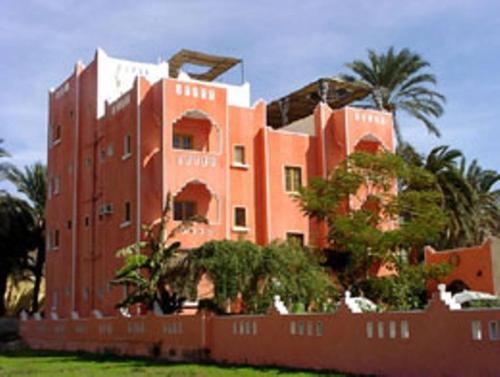 a large building with a large clock on it, El Fayrouz Hotel in Luxor