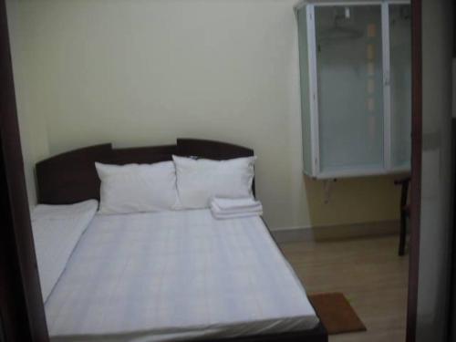 a bed with a white comforter and pillows, 51 GuestHouse - 1st Branch in Dien Bien Phu
