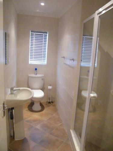 a bathroom with a sink, toilet and tub, Airport Lodge Guest House in Johannesburg