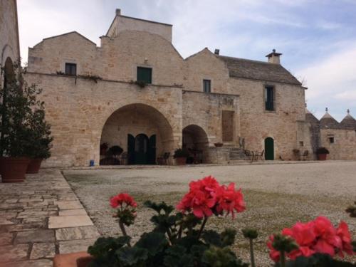 a large stone building with a clock on it, Masseria Sant'Elia in Martina Franca