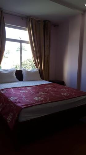 a bedroom with a bed and a window, Hai Duong Guesthouse in Hoa Binh