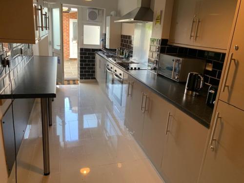 a kitchen with white cabinets and white appliances, Serviced Accommodations in Luton