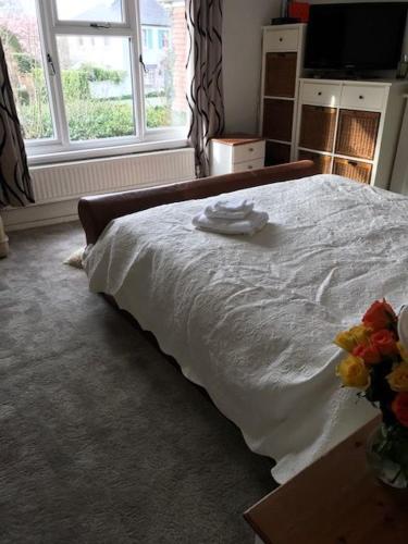 a bed with a white blanket on top of it, West End Lodge in London