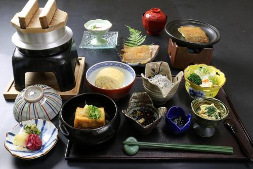 a table topped with bowls of food and utensils, Manseiro in Nachikatsuura