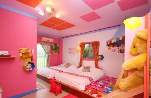 a bedroom with a pink teddy bear sitting on the bed, 101 Homestay in Yilan