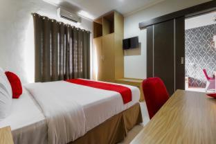 a hotel room with two beds and a television, RedDoorz Plus near Pantai Losari in Makassar