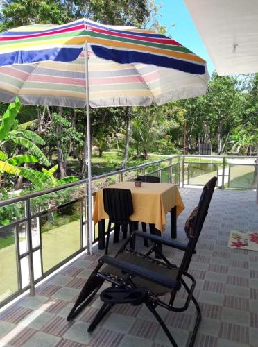 a patio area with a table and chairs and umbrellas, Gialyn's Bed and Breakfast in Bohol