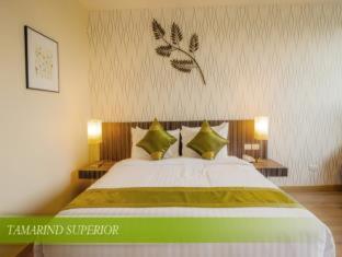a bedroom with a white bedspread and a white comforter, Tamarind Garden Hotel (SHA Extra Plus) in Rayong