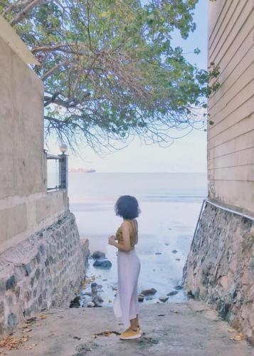 a little girl standing on a sidewalk next to a stone wall, SeaSala Hotel in Vung Tau