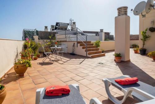a patio area with chairs, tables, and a balcony, Apartamento MINAGA 1 in Nerja