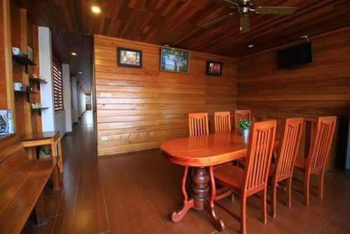 a dining room with a wooden table and chairs, บ้านพักศรีสมบูรณ์ เชียงคาน in Chiangkhan