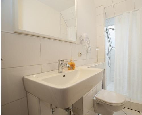 a white toilet sitting next to a sink in a bathroom, Picklapp Apartments in Hamburg