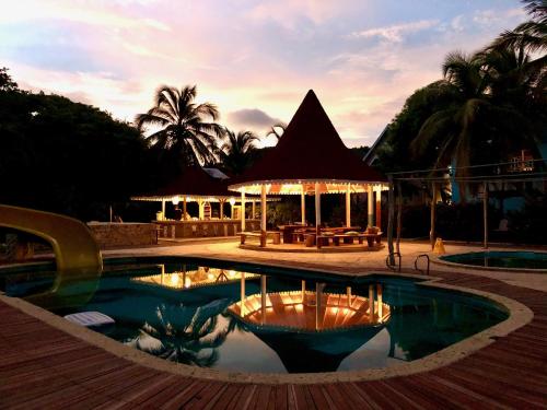 Photo of a pool and gazebo lit up at night with palm trees in the background at the best Cartagena hostel in the islands