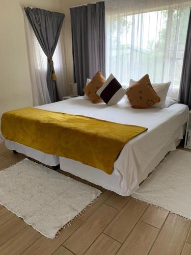 a bedroom with a white bedspread and pillows, 77 on Sissons in Mthatha