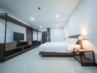 a hotel room with a bed, chair, and nightstand, Tassana Place in Chonburi