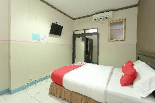 a bedroom with a bed and a mirror, OYO 2057 Hotel Kharisma in Banjarmasin