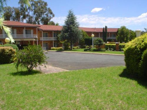 a large green lawn with a white house, Coachmans Rest Motor Lodge in Coonabarabran